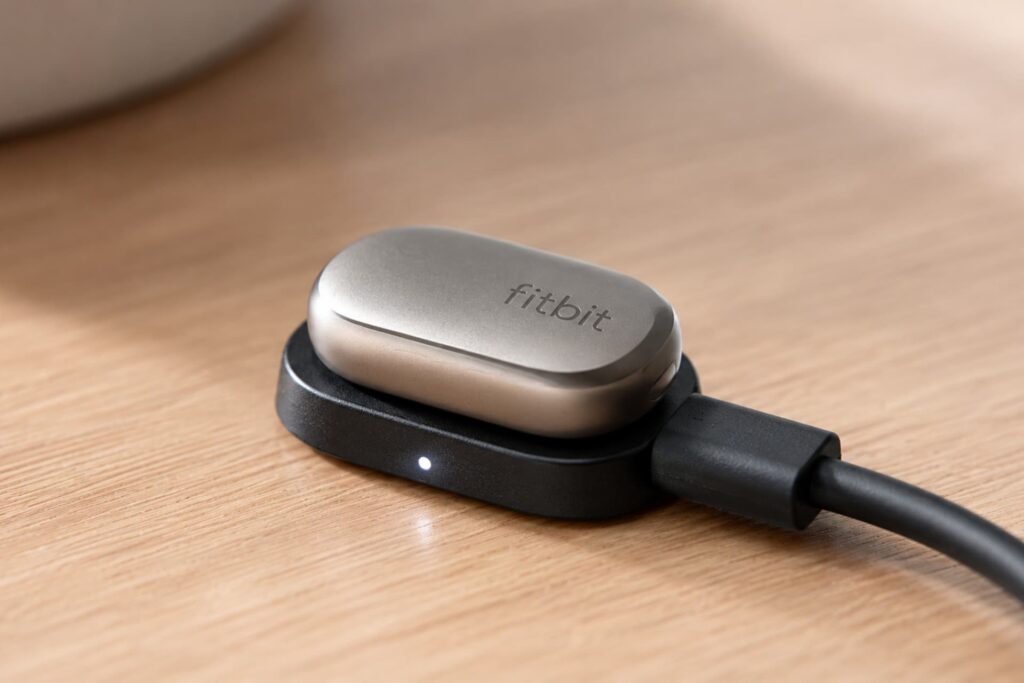 The Fitbit Air being fast-charged on a magnetic base for all-day power,